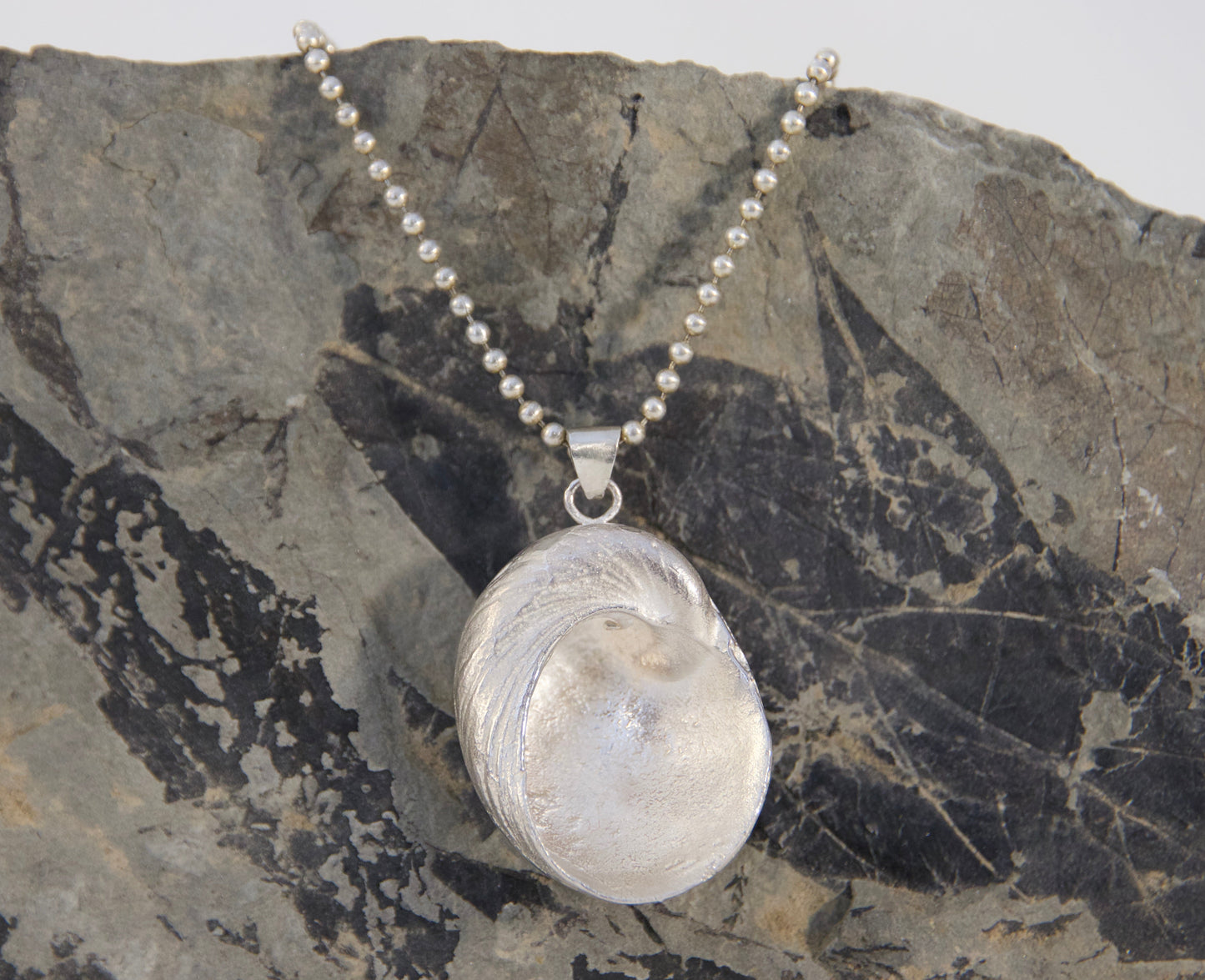 Necklace with a pendant on a textured stone surface