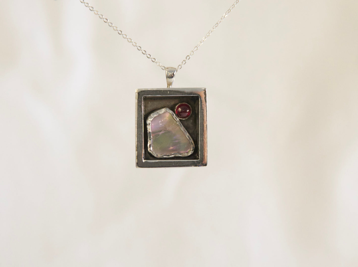 Sterling silver abalone garnet pendant.
