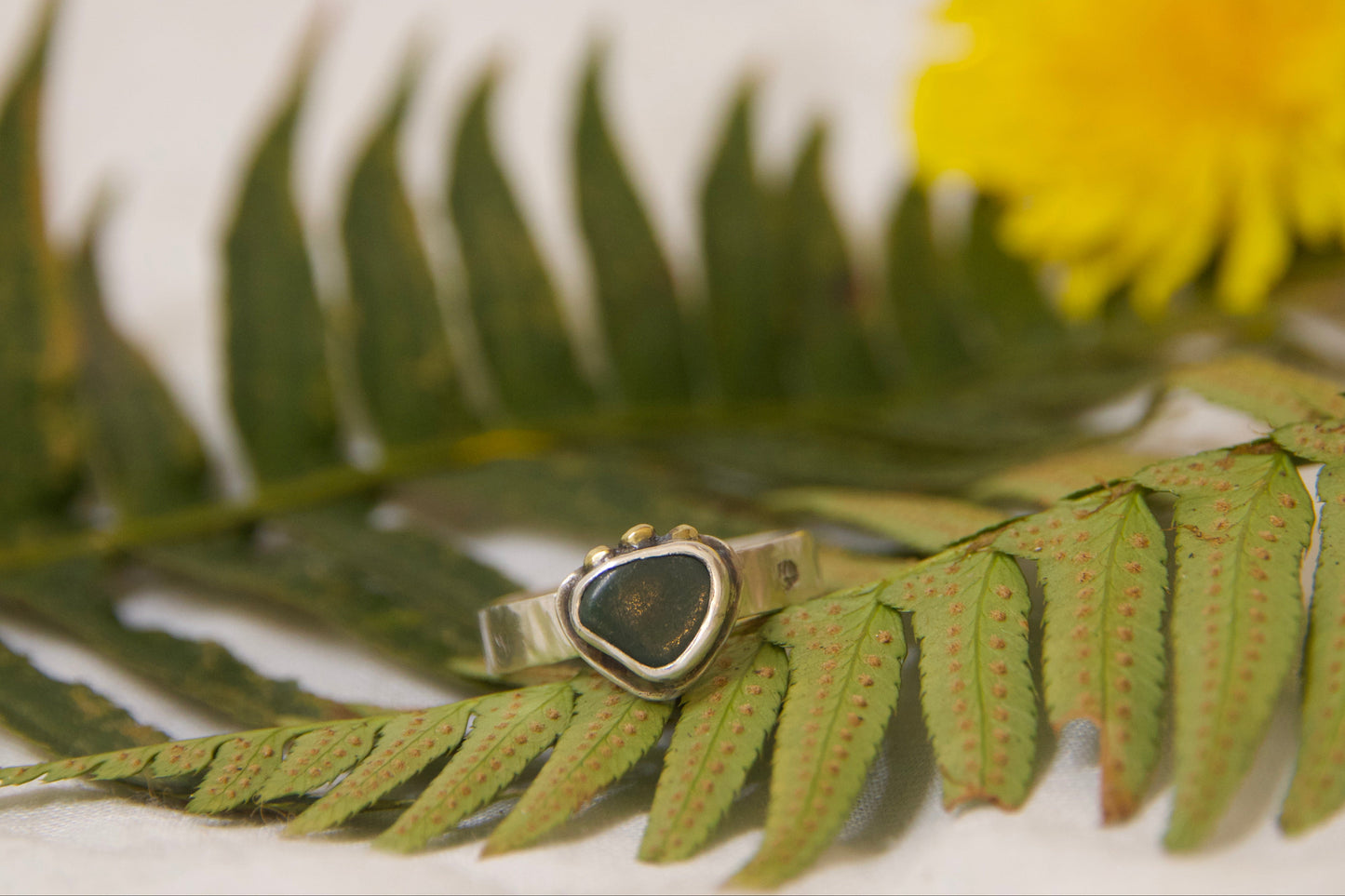 Brass and sterling silver ring with leaf patterns on either side. Handmade one of a kind jewelry 