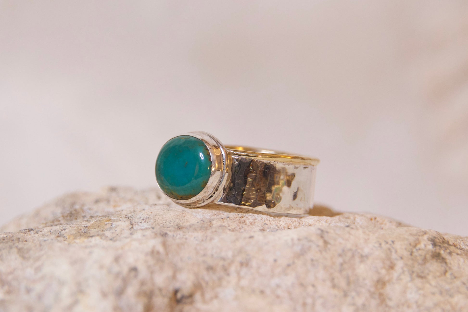 Ring with a turquoise stone sitting on a rock