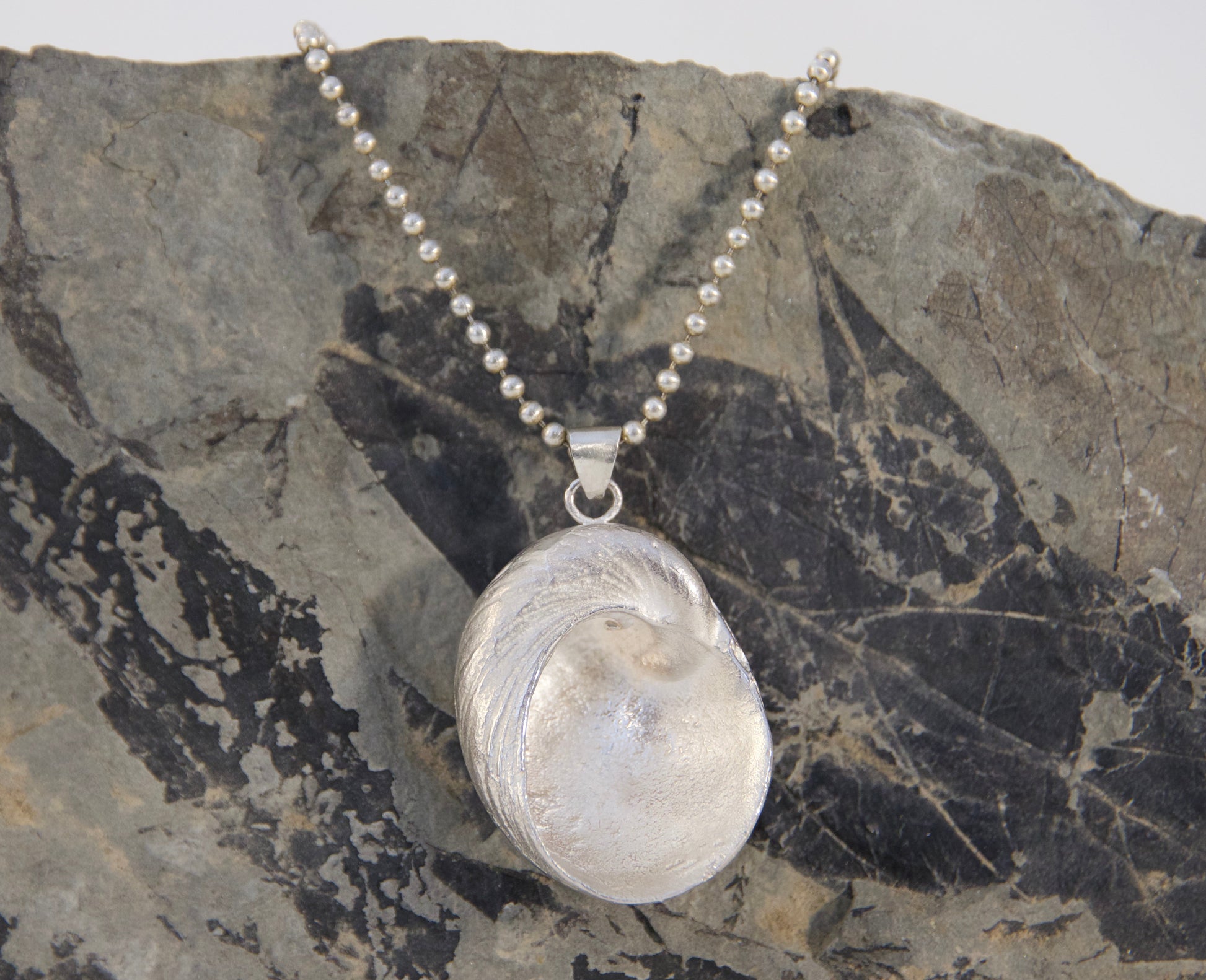 Necklace with a pendant on a textured stone surface