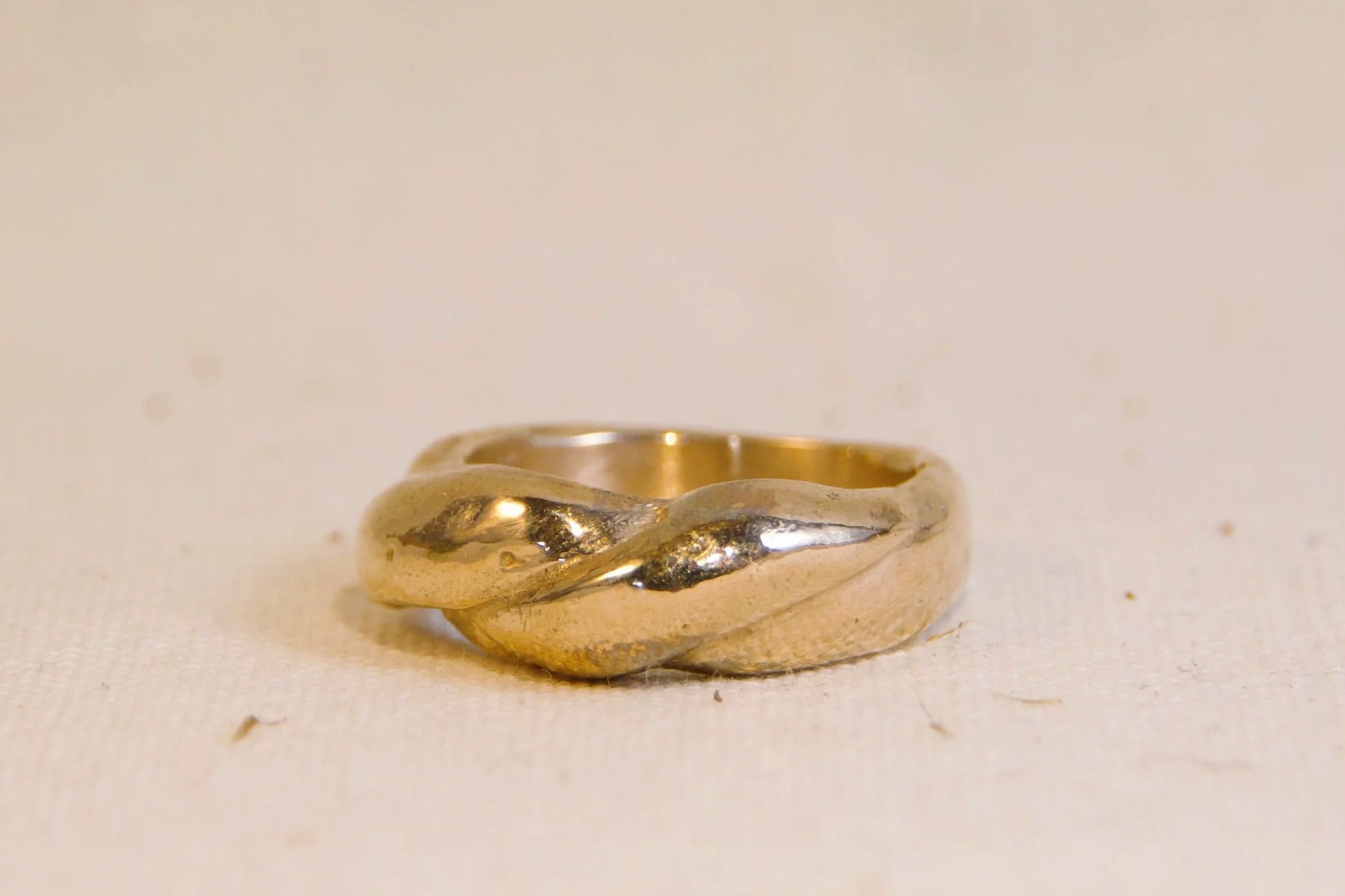 Bronze ring on a beige surface