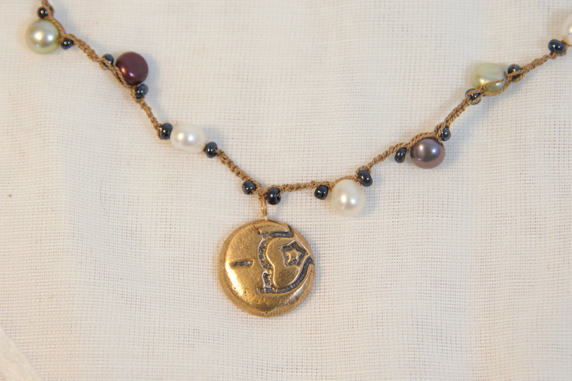 Necklace with beads and a gold pendant on a white background