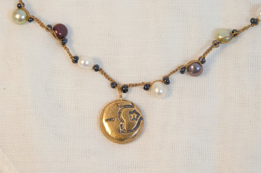Necklace with beads and a gold pendant on a white background