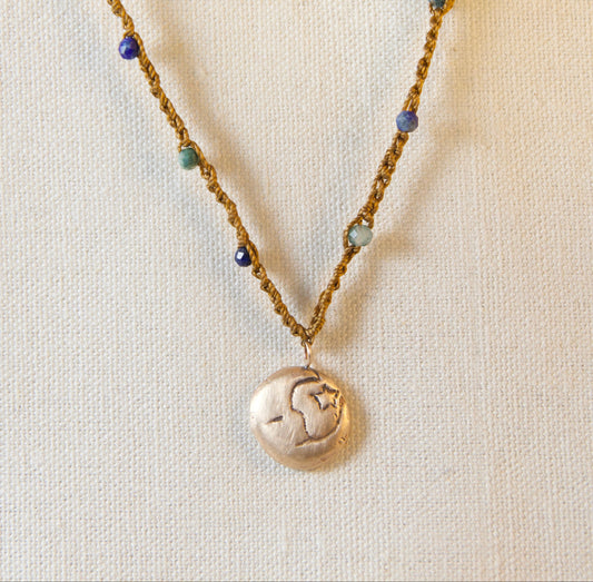 Necklace with a round pendant on a beige background