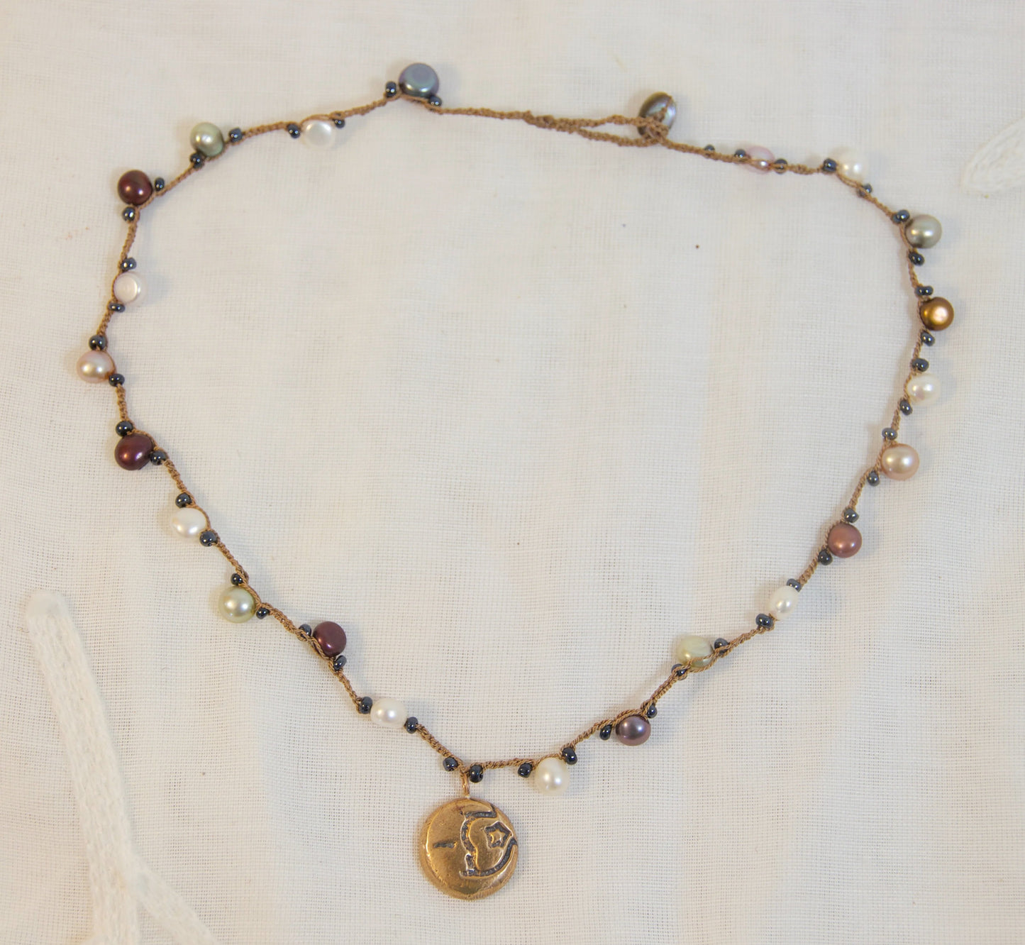 Necklace with beads and a pendant on a light background