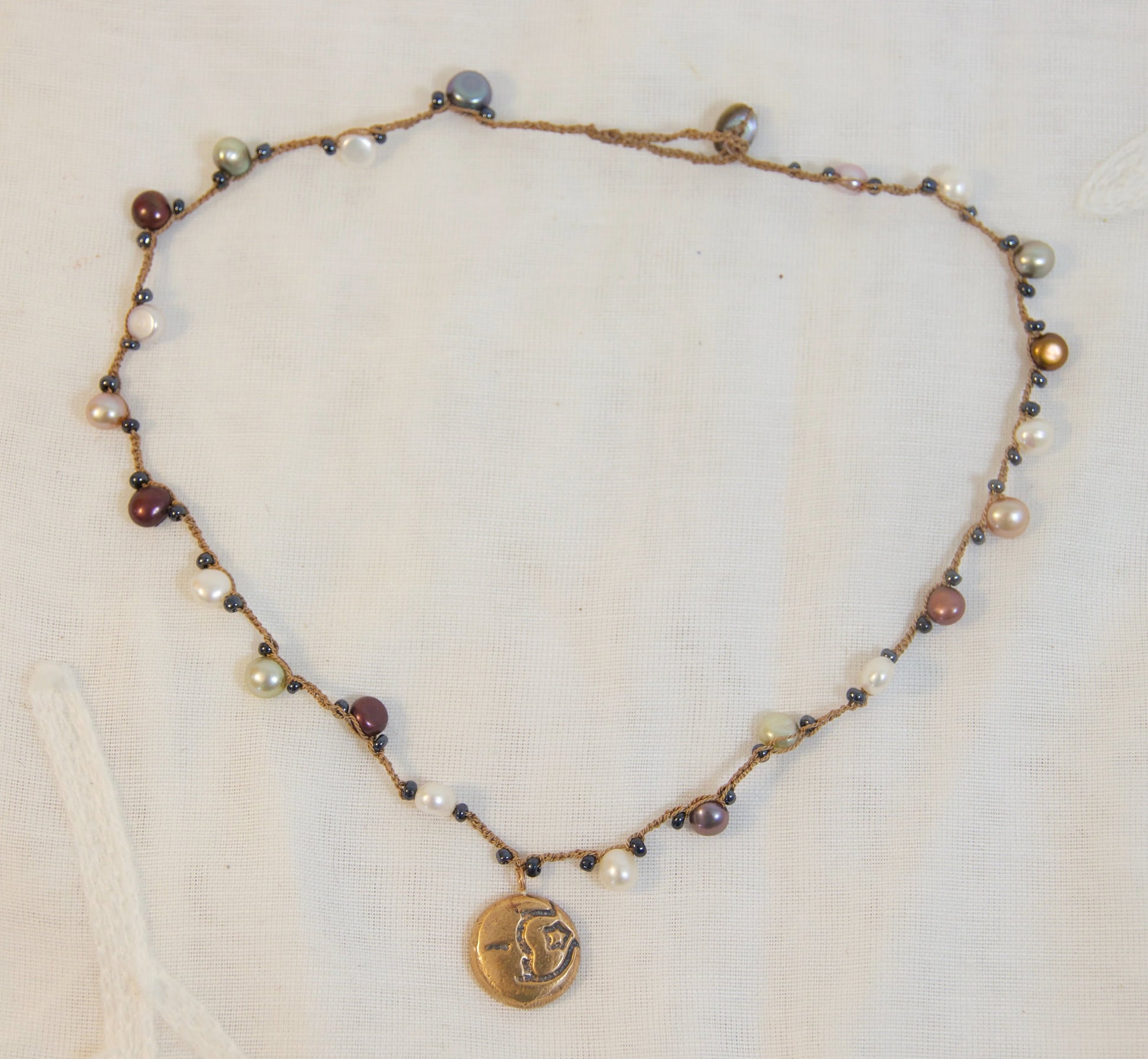 Necklace with beads and a pendant on a light background