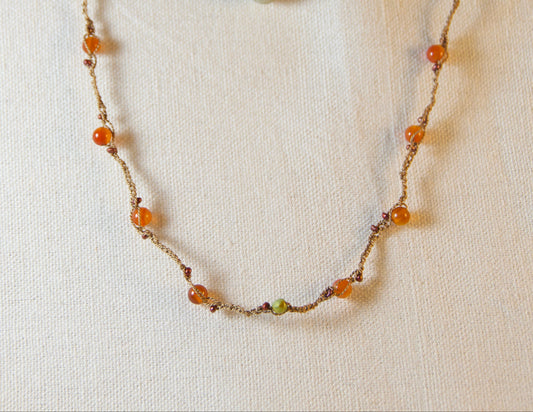 Necklace with multicolored beads on a white fabric background