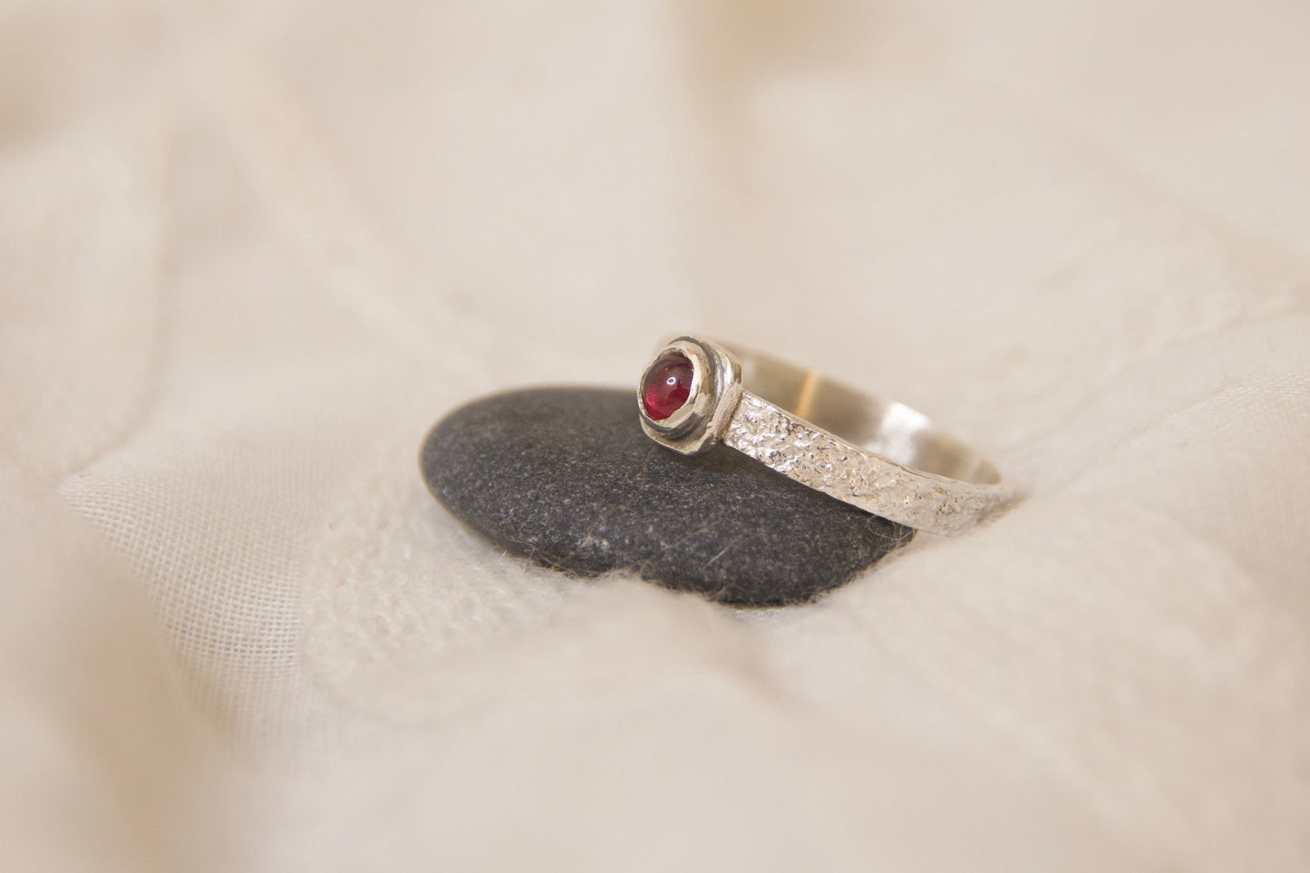 Naturally textured sterling silver ring with a garnet stone