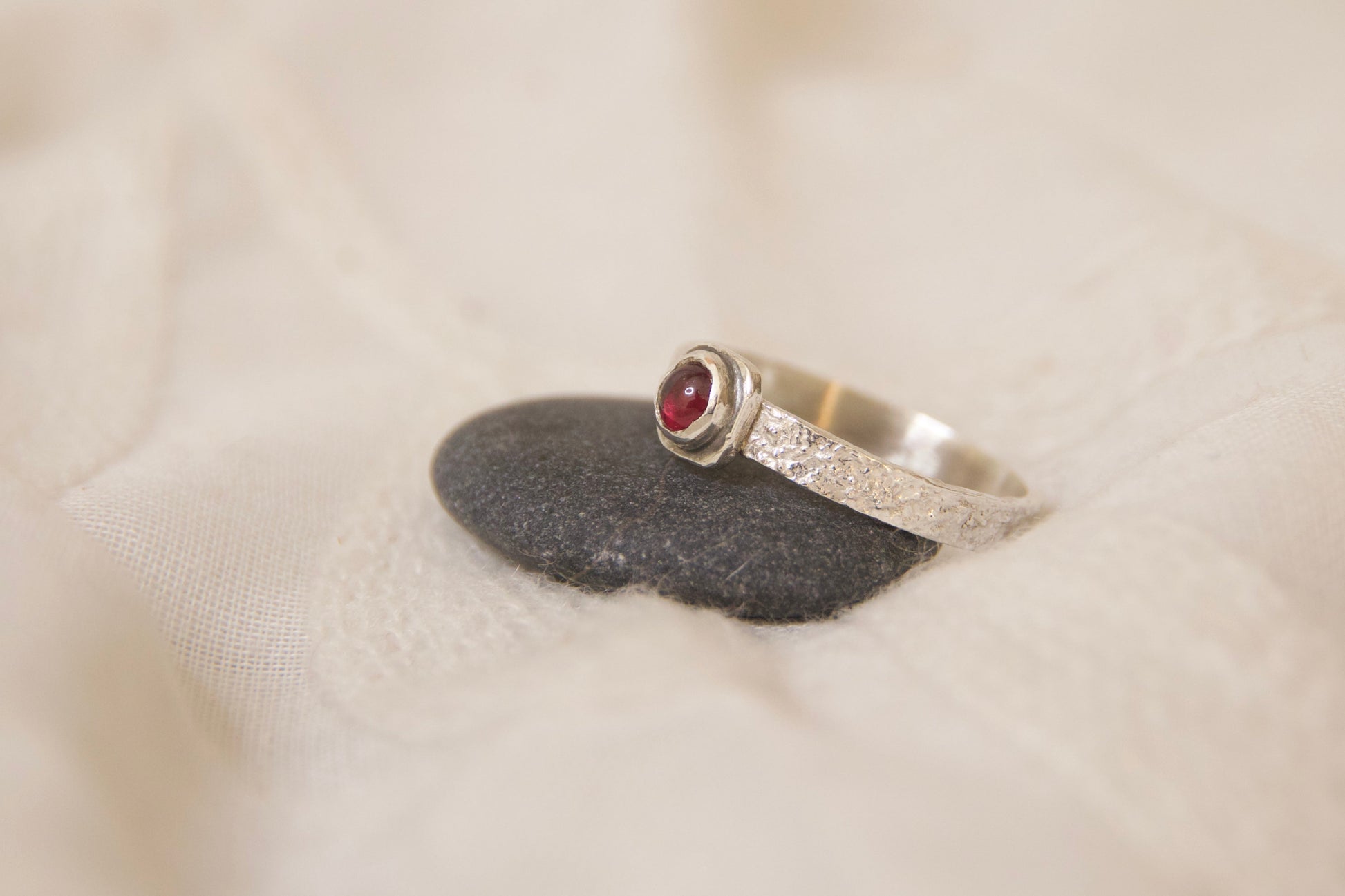 Naturally textured sterling silver ring with a garnet stone