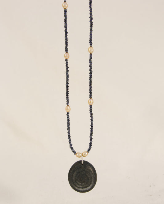 Necklace with a black pendant on a light gray background