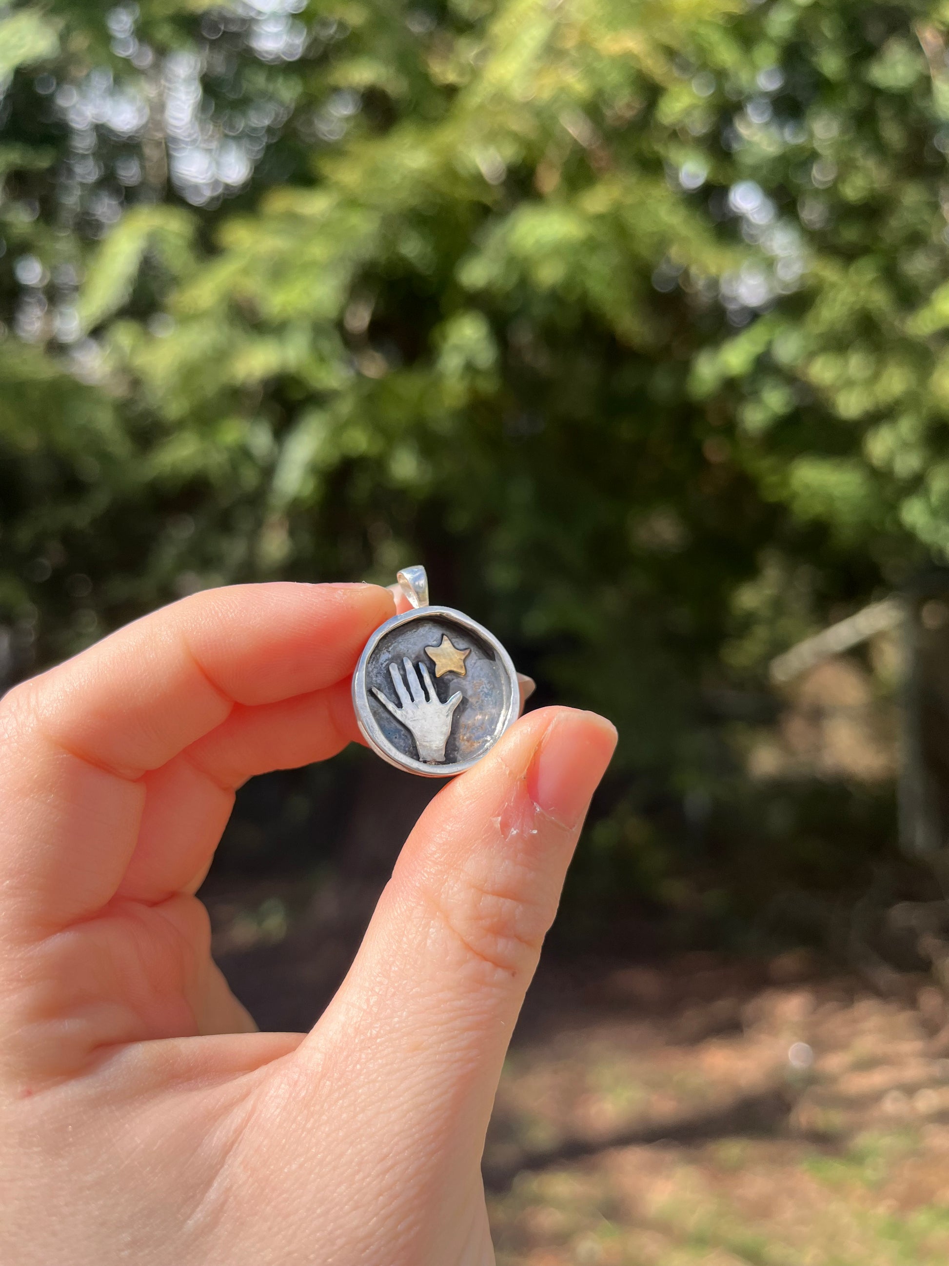 Skillfully cut out sterling silver hand reaching for brass star one of a kind jewelry