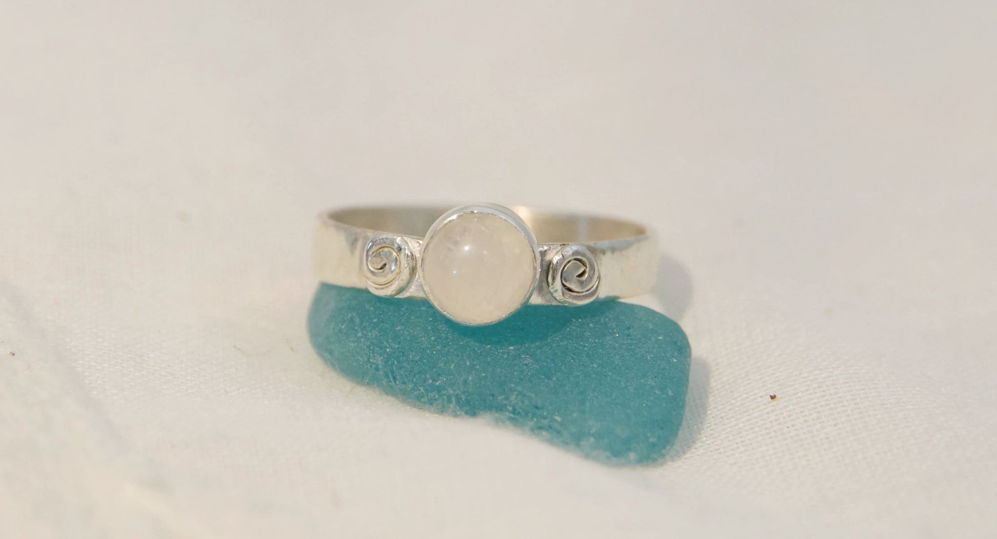 Moonstone center stone between two swirls 