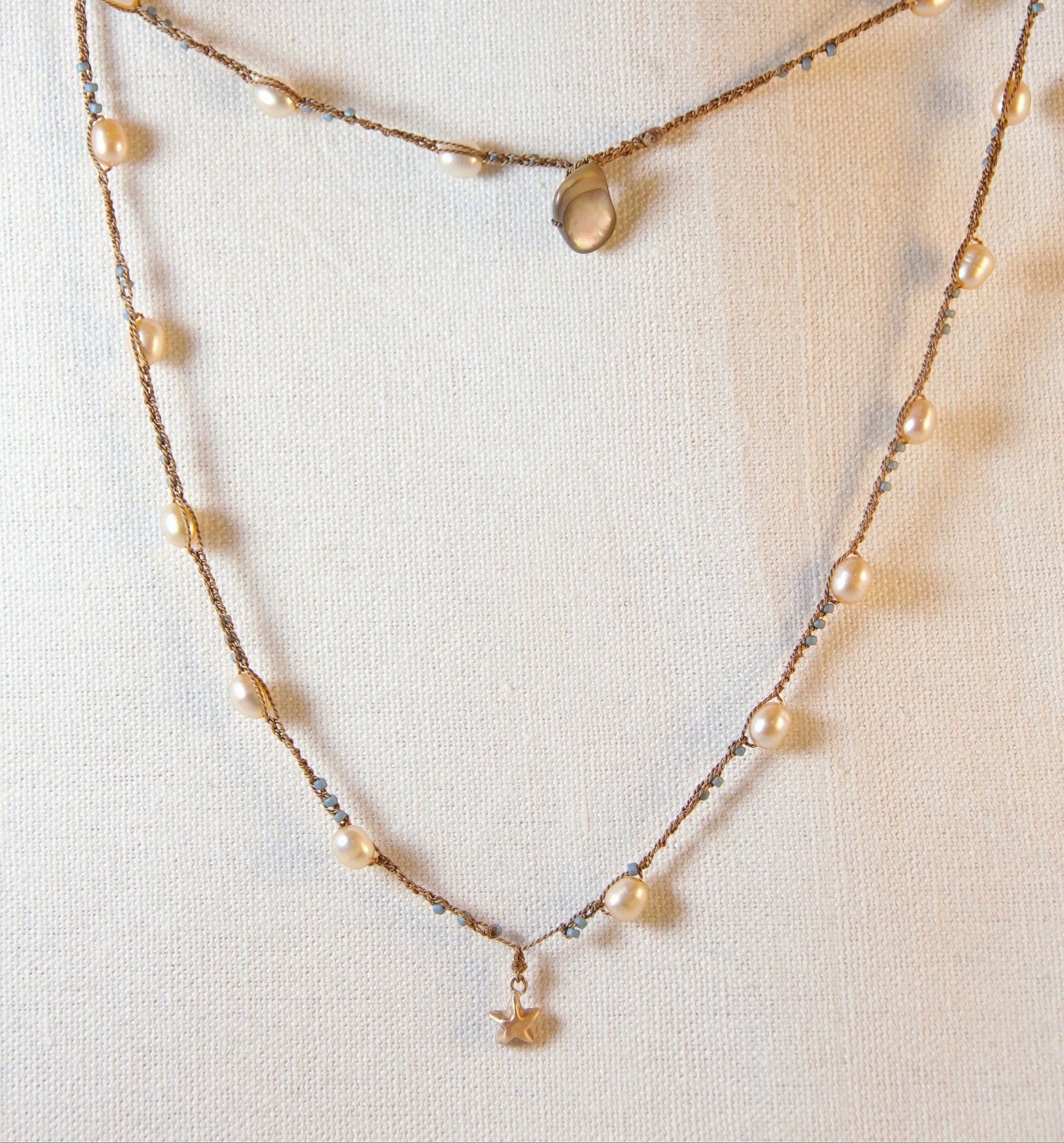 Pearl necklace on a mannequin with a plain background