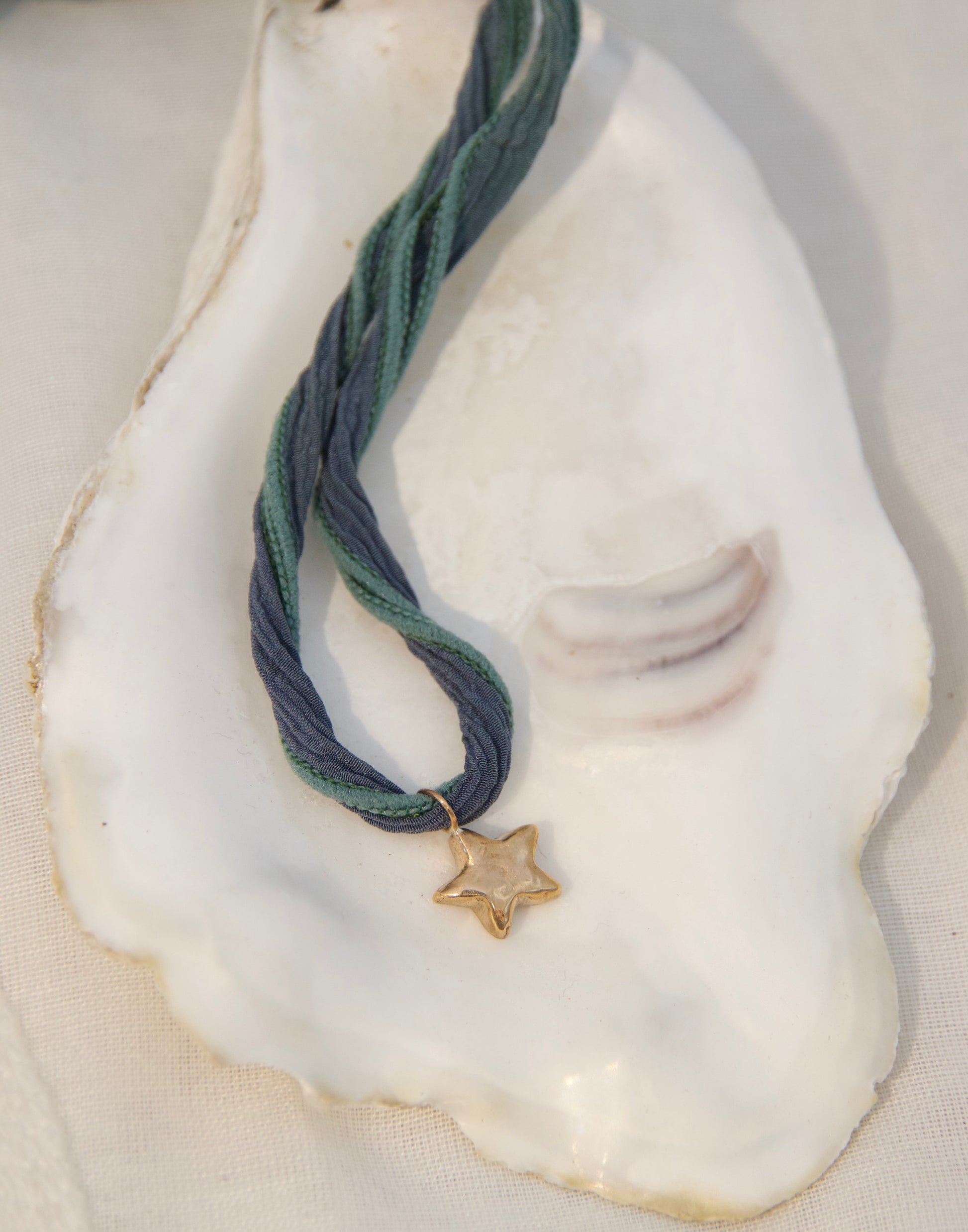 Silk corded necklace with a golden star pendant