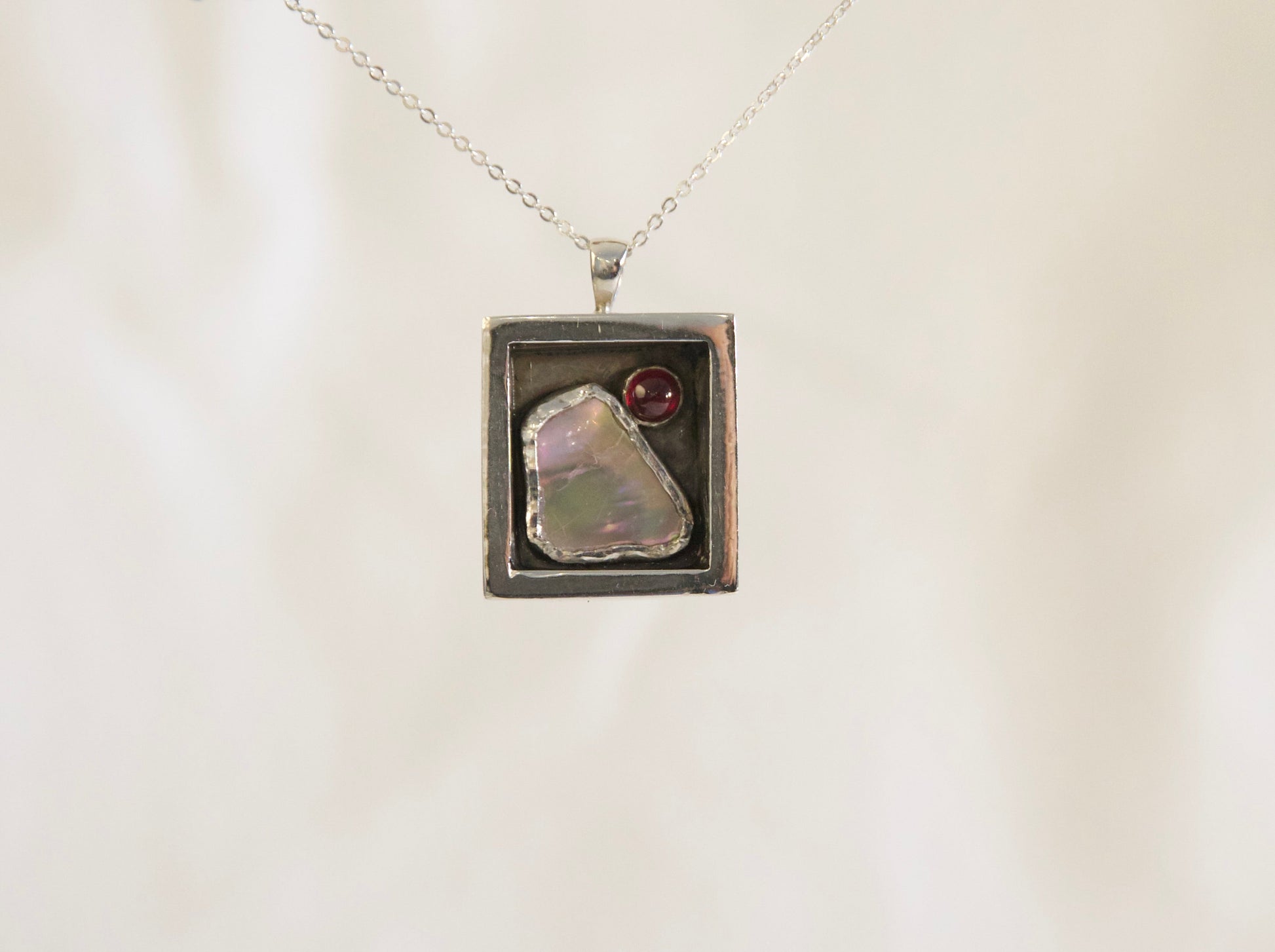 Sterling silver abalone garnet pendant.