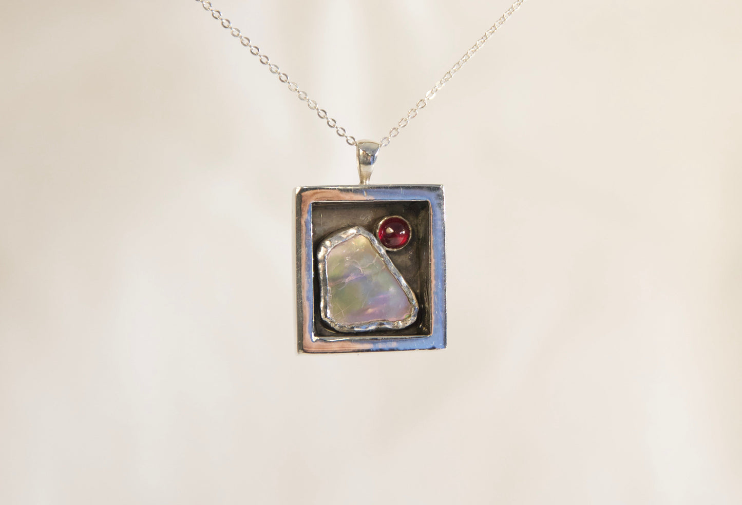 Necklace with a pendant featuring a natural stone on a branch against a neutral background