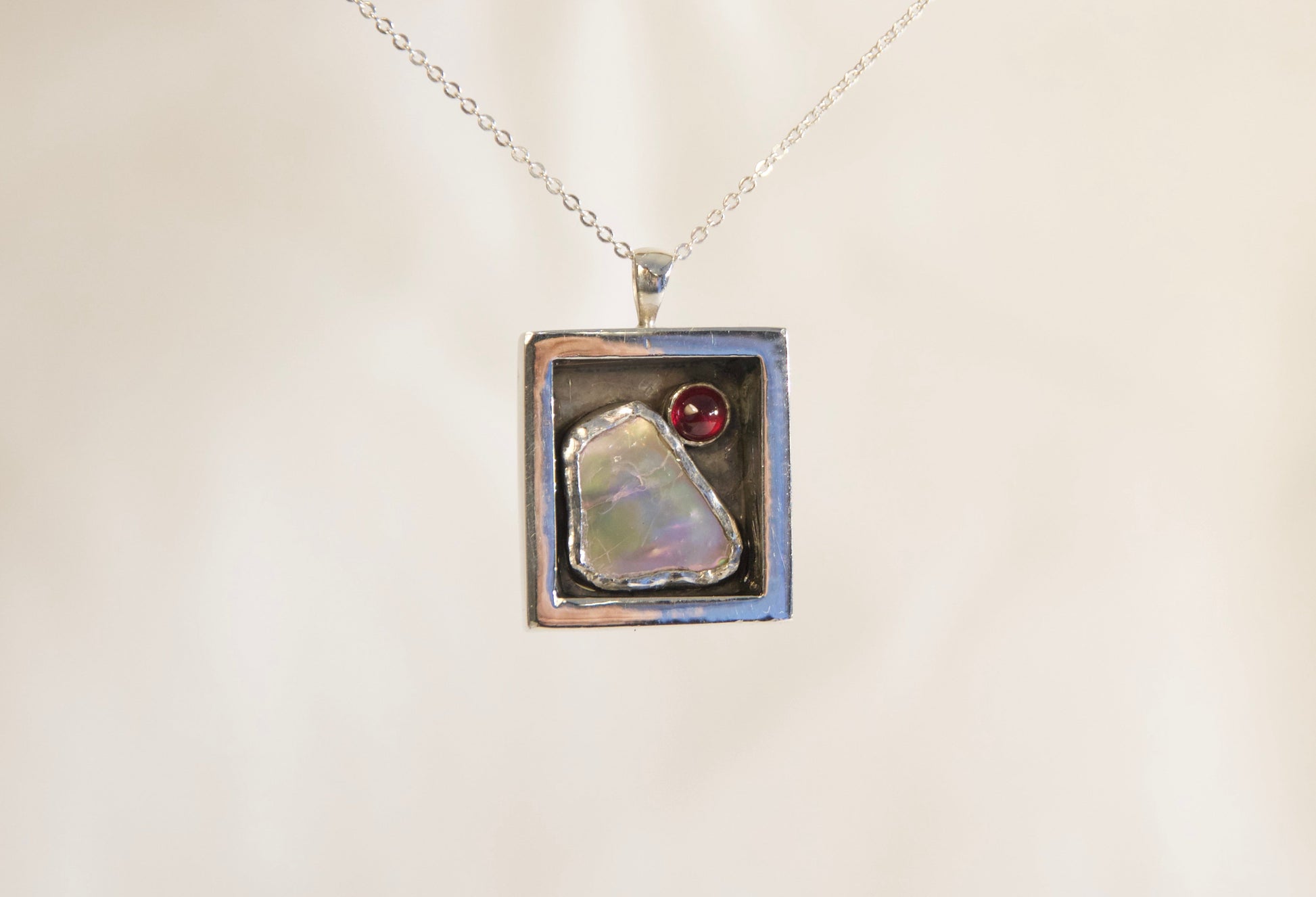 Necklace with a pendant featuring a natural stone on a branch against a neutral background