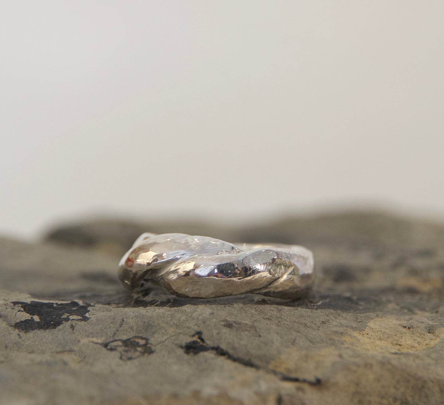 Silver ring on a textured stone surface