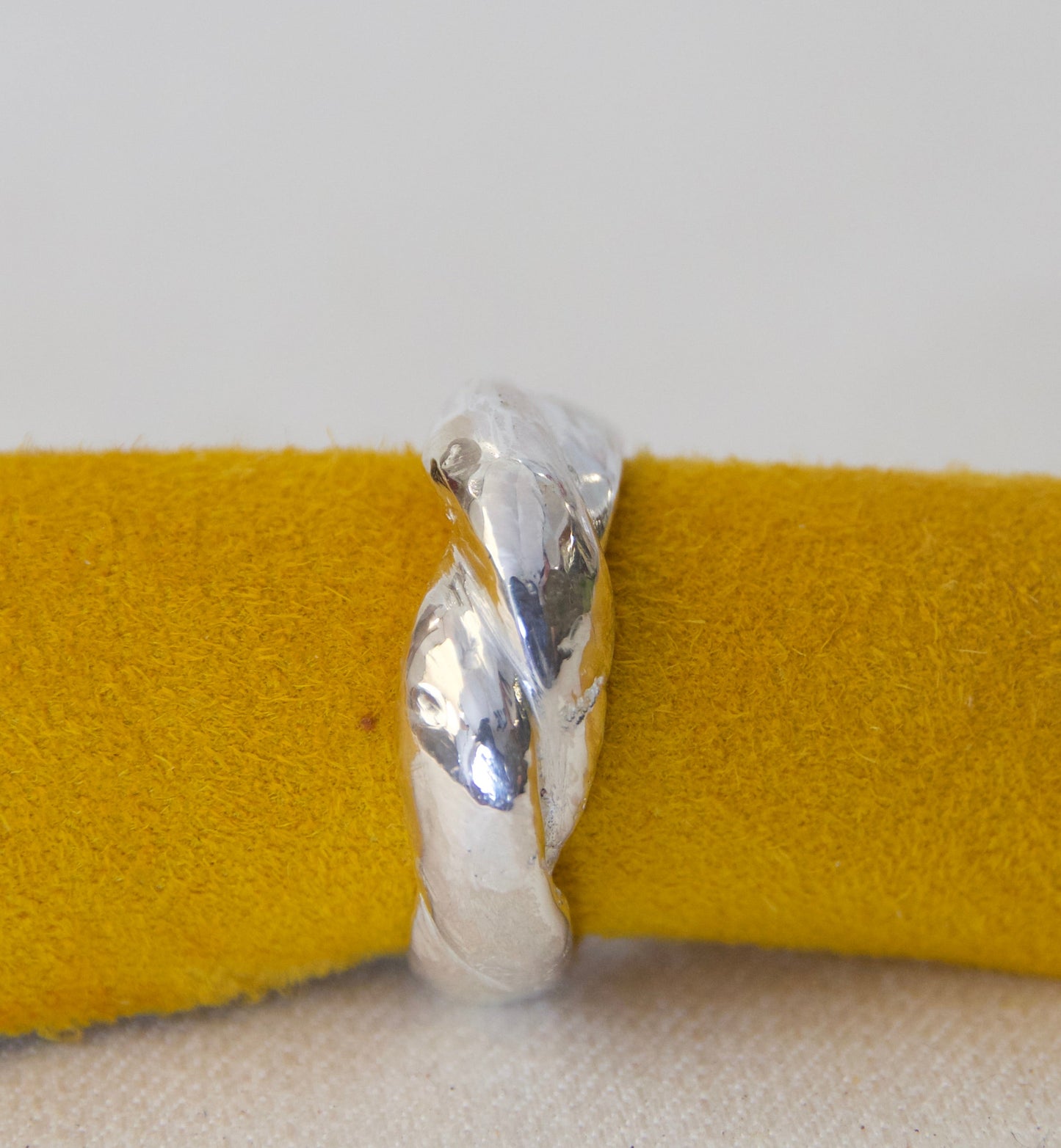 Silver ring on a yellow fabric background