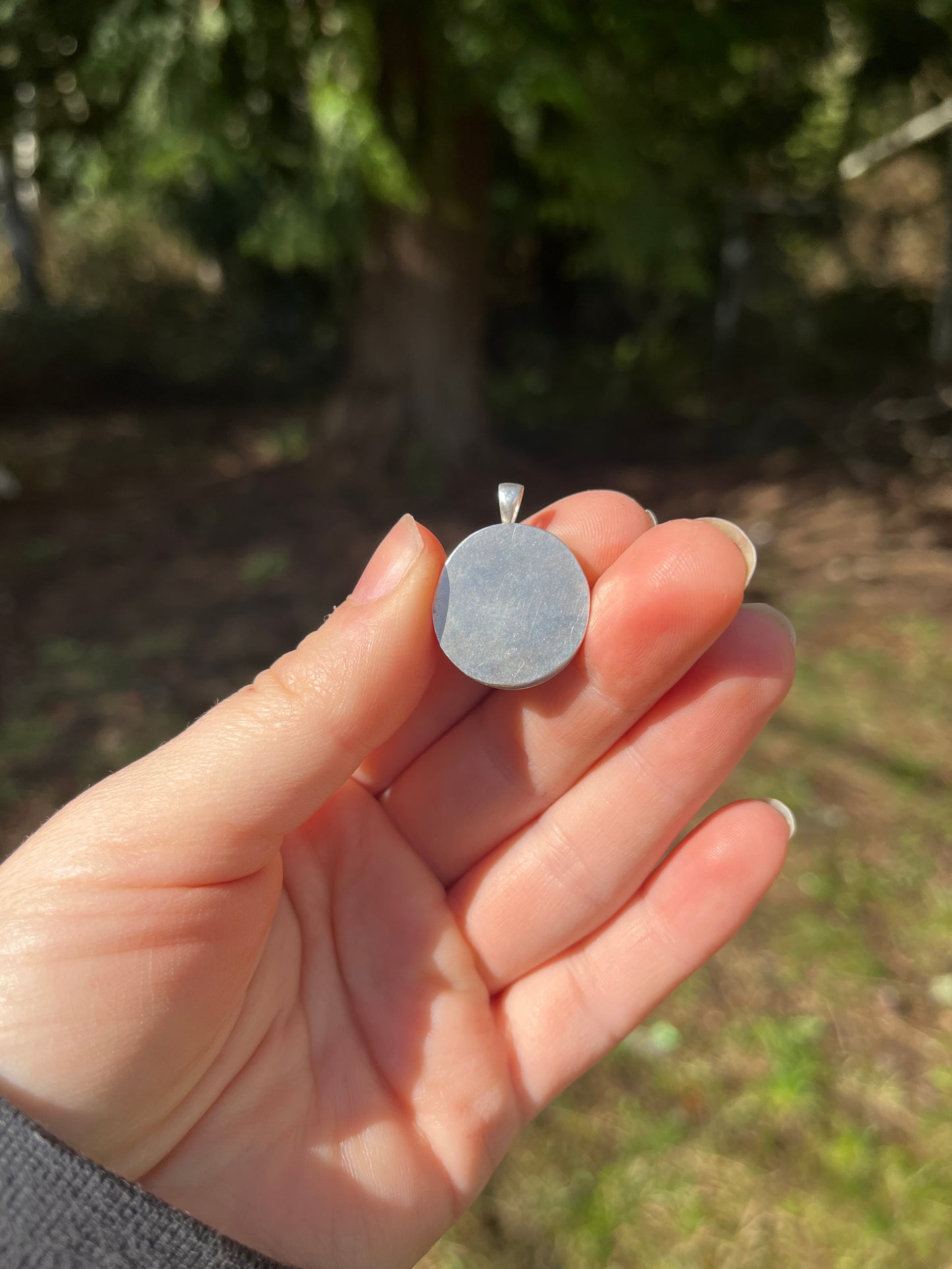 Back of handmade sterling silver and brass hand cut pendant 